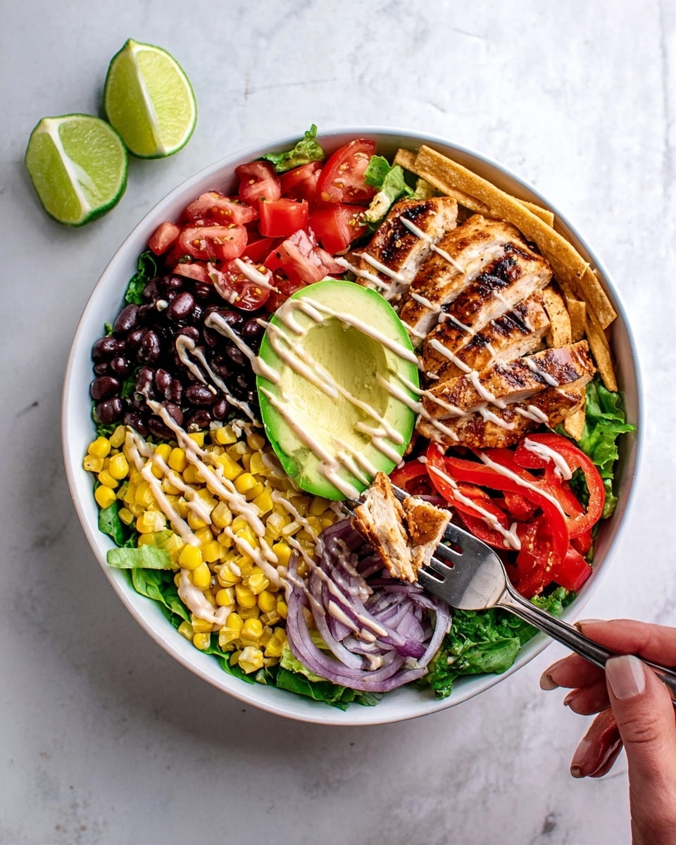 The image shows a white bowl filled with layered salad ingredients arranged around grilled chicken breast in the center. Starting from the bottom left, there is a layer of yellow corn kernels, followed by a layer of black beans. Next to the beans is grilled chicken with visible char marks, topped with a light drizzle of creamy sauce. Above the chicken is a sliced half avocado with the same sauce drizzled on top. To the right of the avocado, there are thin crispy tortilla strips and some purple onion slices. Below the onions, there are bright red bell pepper rings on a bed of green leafy lettuce. On the left side of the bowl, diced red tomatoes sit beside two lime slices resting on the edge of the bowl. A woman's hand is holding a fork, taking a piece of grilled chicken from the bottom right part of the bowl. The bowl is placed on a white marbled surface with two lime slices beside it. Photo taken with an iphone --ar 4:5 --v 7