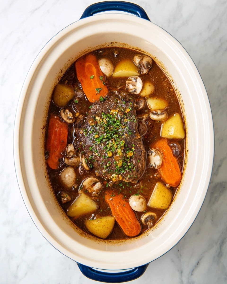 The image shows a slow cooker filled with a dark brown stew, centered by a large piece of cooked meat covered with some small green herb bits. Around the meat, there are several thick slices of orange carrots, light yellow potato chunks, and many small white and brown mushroom slices floating in the rich broth. The stew fills the white oval slow cooker, which has blue handles, and sits on a white marbled surface. photo taken with an iphone --ar 4:5 --v 7